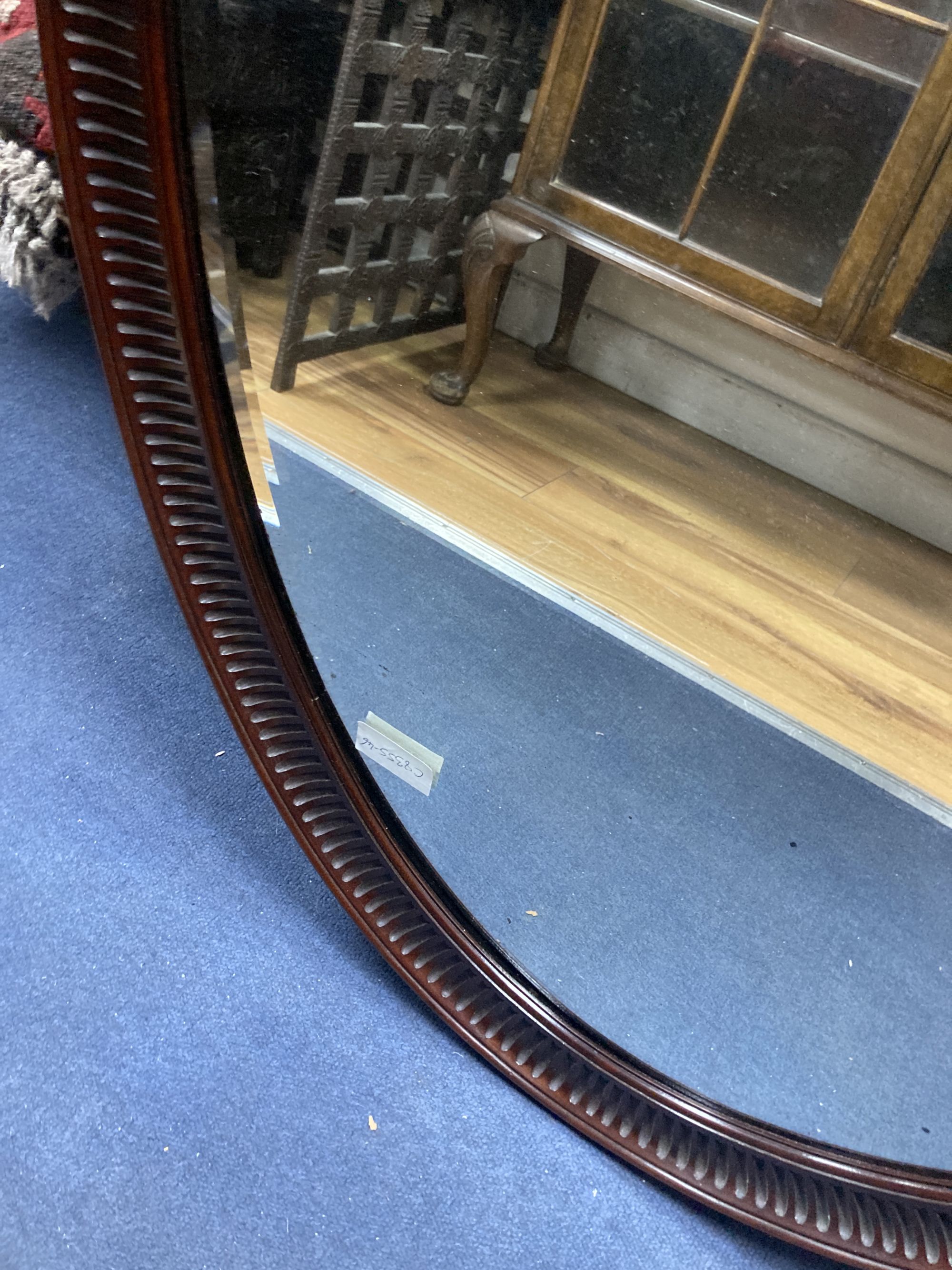 A 1920s oval-framed mahogany wall mirror, width 70cm, height 100cm